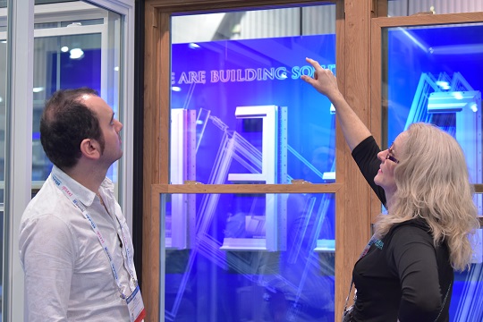 two people discussing a window unit at glassbuild