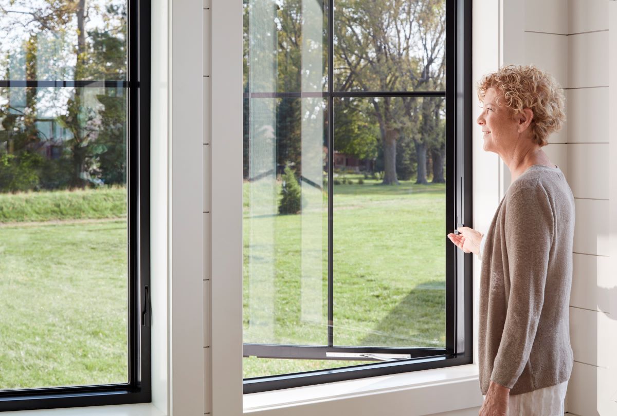 woman using easy-slide operator to close casement and awning windows