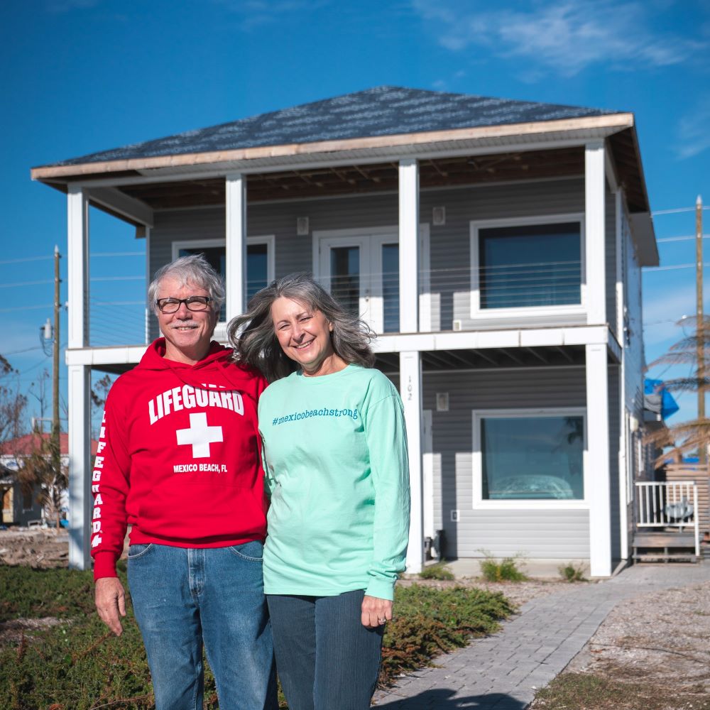 couple in front of beach home