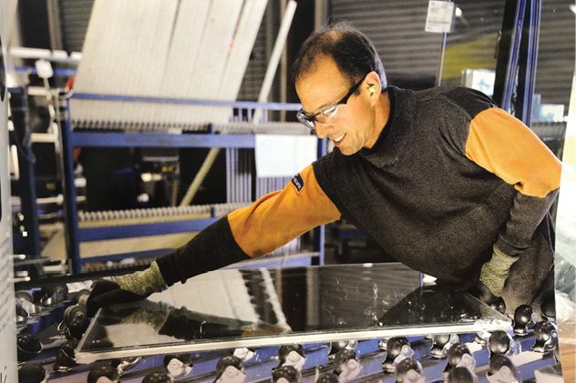 worker on fabrication line wears PPE Jacket and gloves