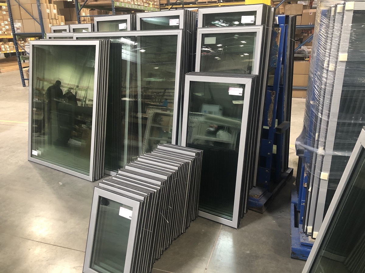 thin glass window units stacked together on factory floor