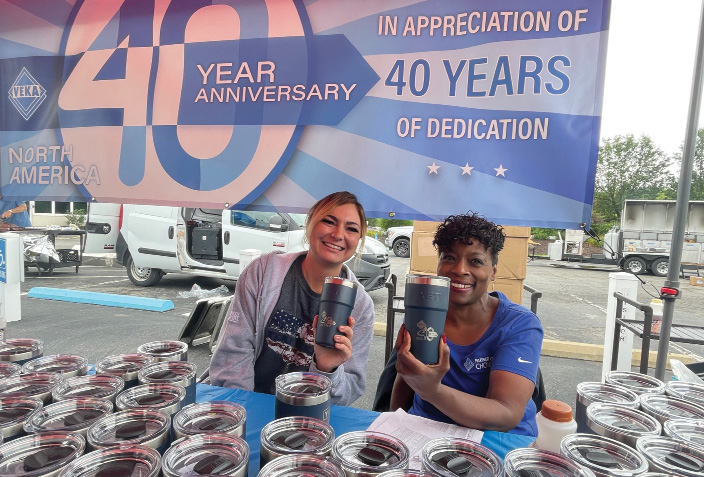 VEKA employees hand out anniversary mugs