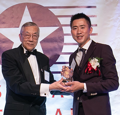 Chen (right) receives the award from John Wang, President of the non-profit Asian American Business Development Center.
