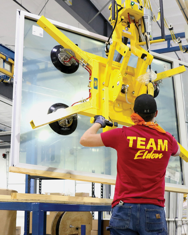 Worker using equipment to move larger windows