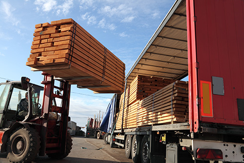 Construction lumber being loaded onto a flatbed truck