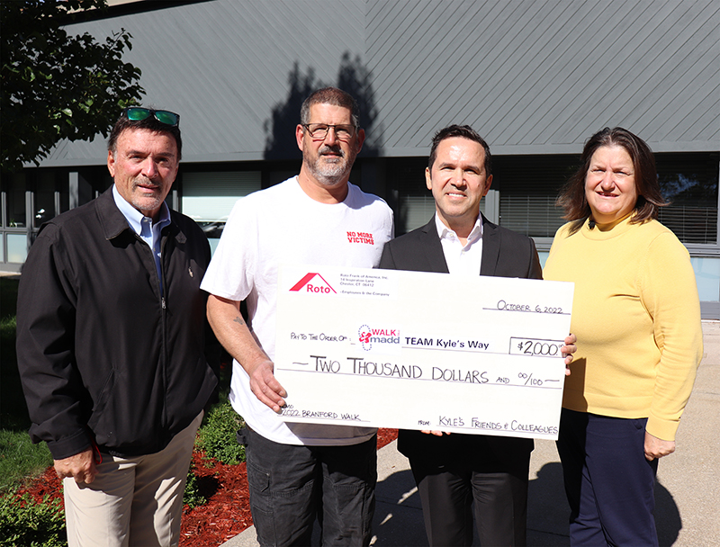 Roto employees stand with fundraising check