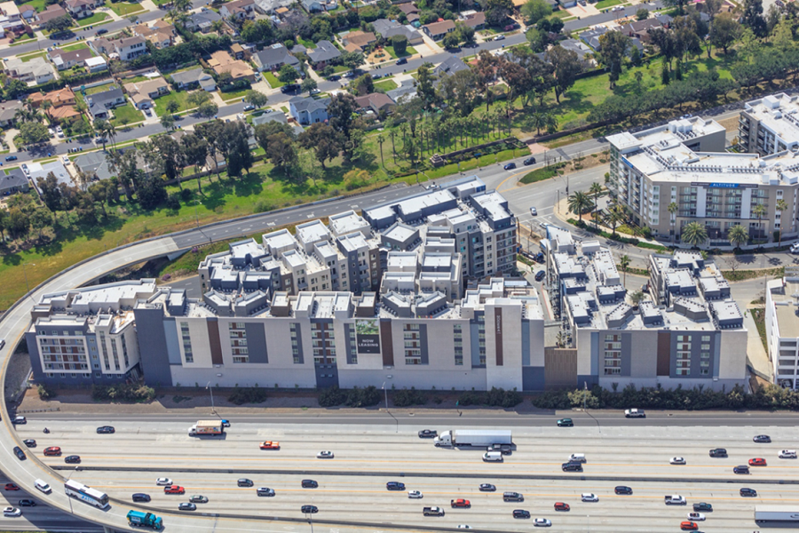 exterior of a multifamily building surrounded by busy interstates