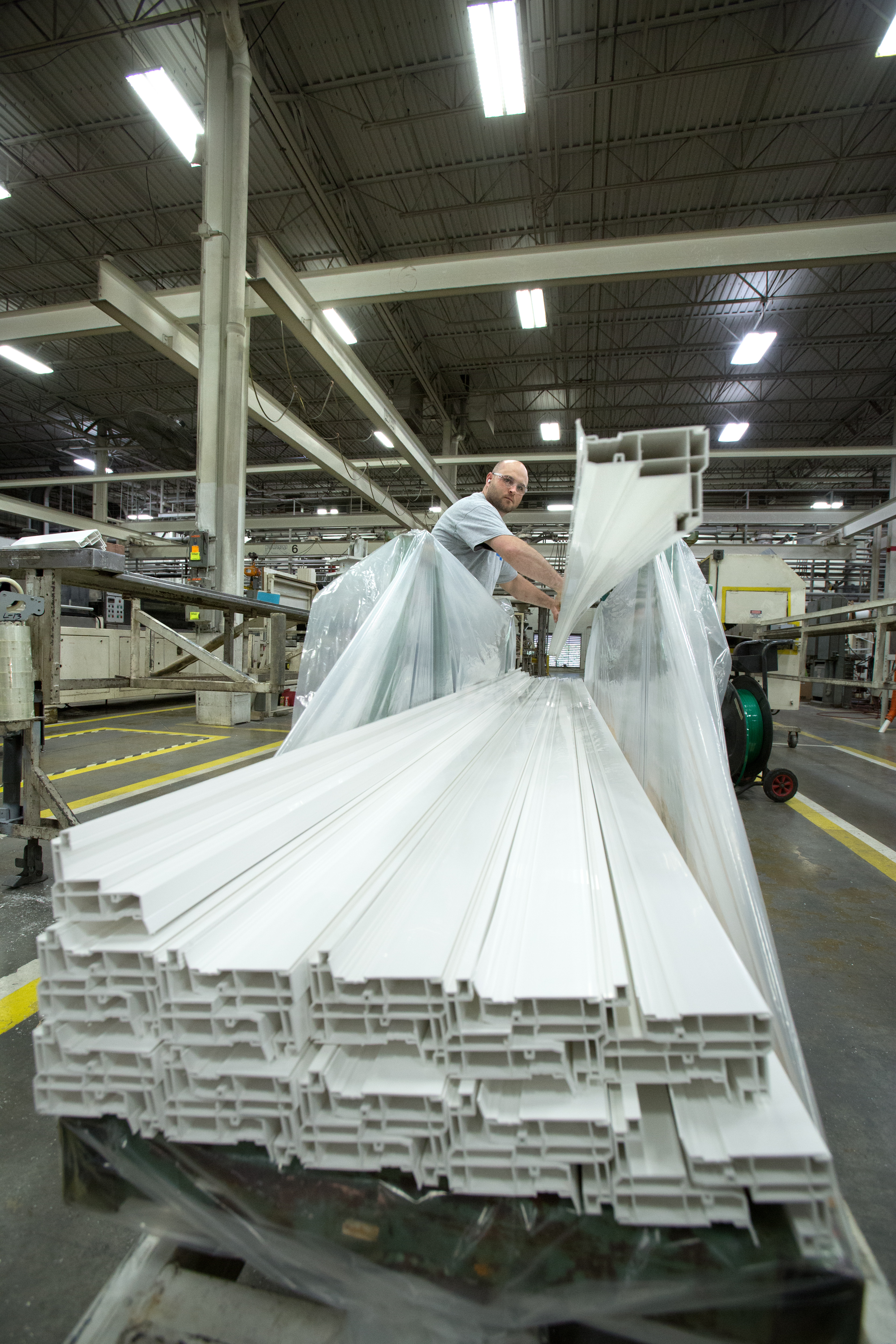 man stacking vinyl extrusions on a cart