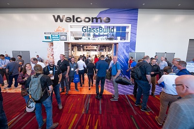 a crowd of people enters the door for GlassBuild