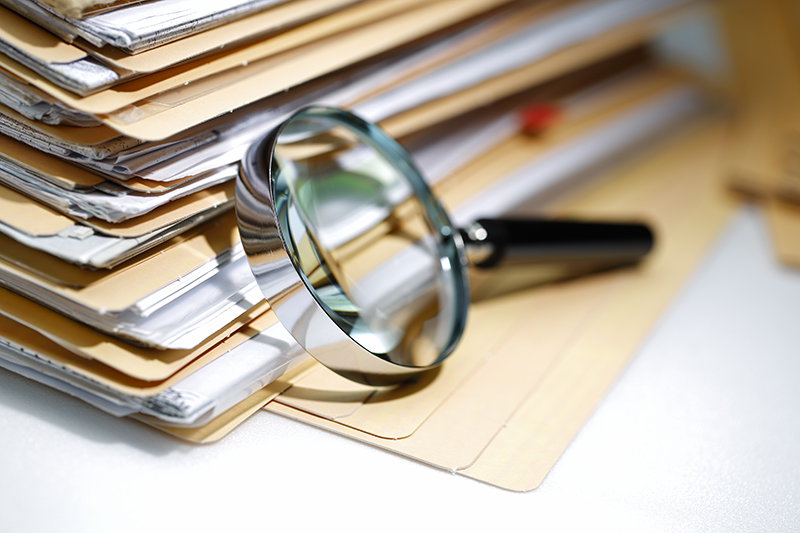 Legal files and magnifying glass