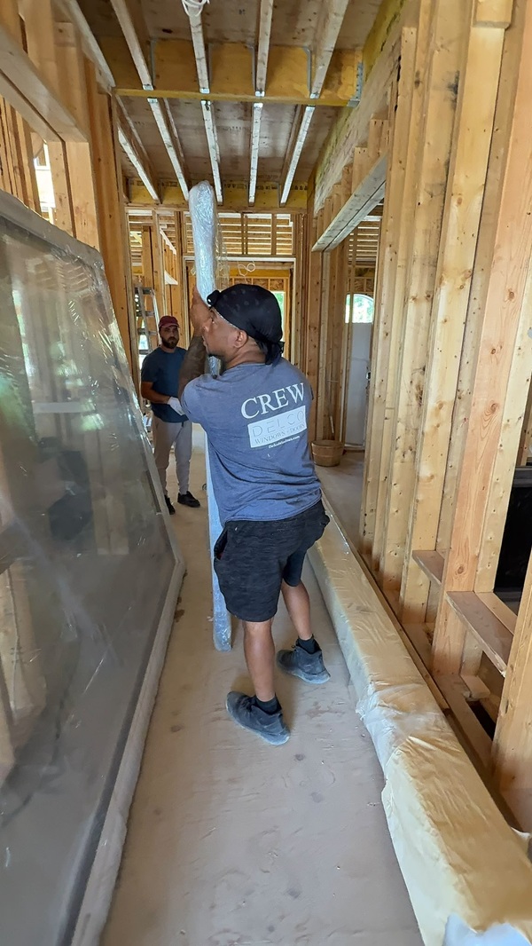 Two installers fitting a sliding patio door assembly in a Toronto home
