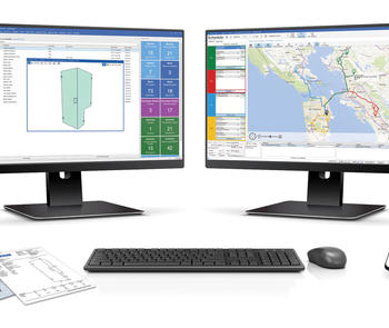 Multiple computer monitors displaying glass job management software