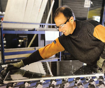 worker on fabrication line wears PPE Jacket and gloves